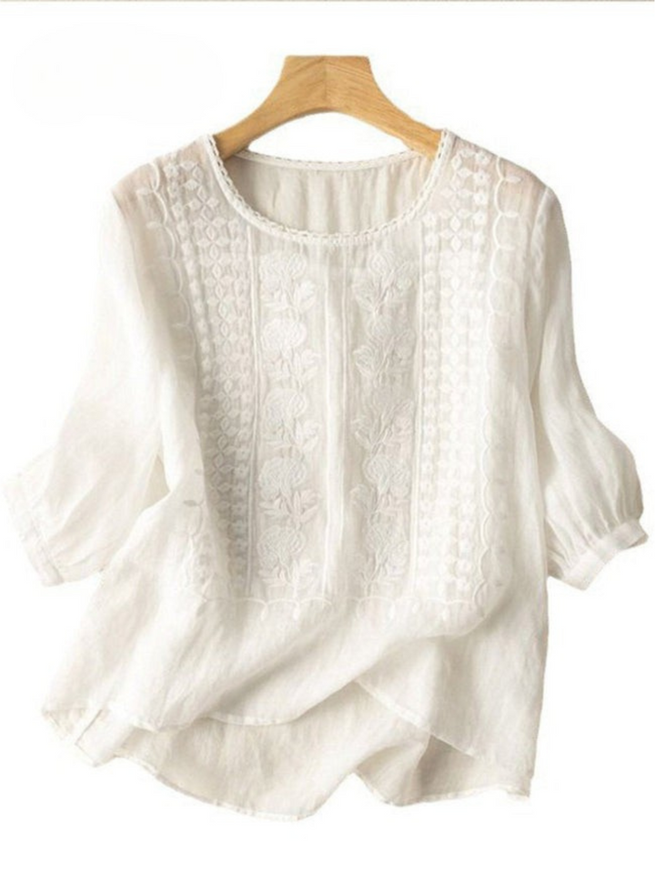 Front view of a white mid sleeve cotton linen embroidery blouse on a wooden hanger