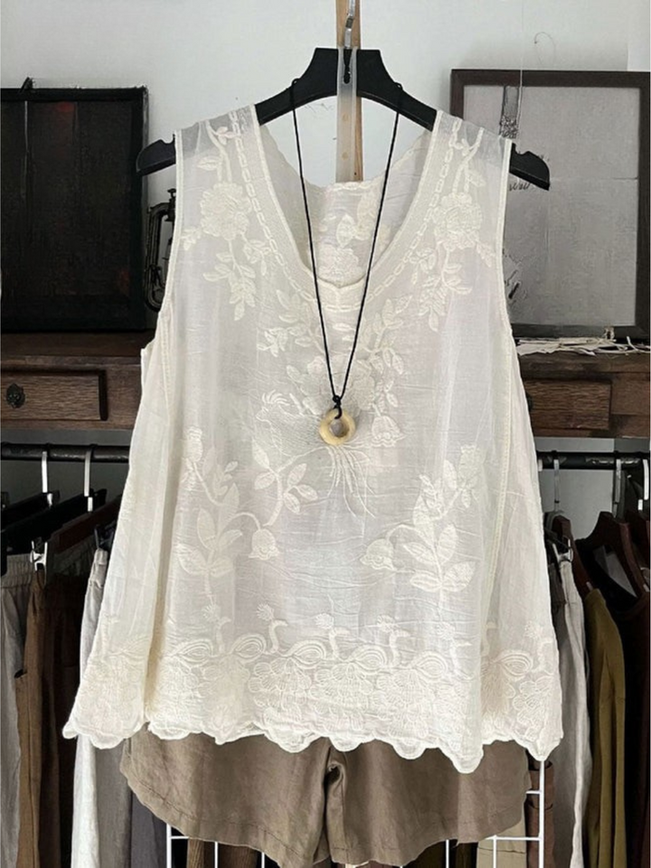 Front view of a white vintage lace sleeveless cotton linen vest top with a scalloped hem and a necklace
