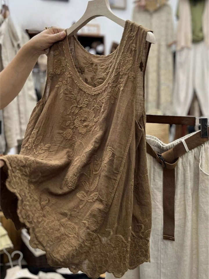 Detail of a brown vintage lace sleeveless cotton linen vest top with embroidered flowers and a scalloped hem