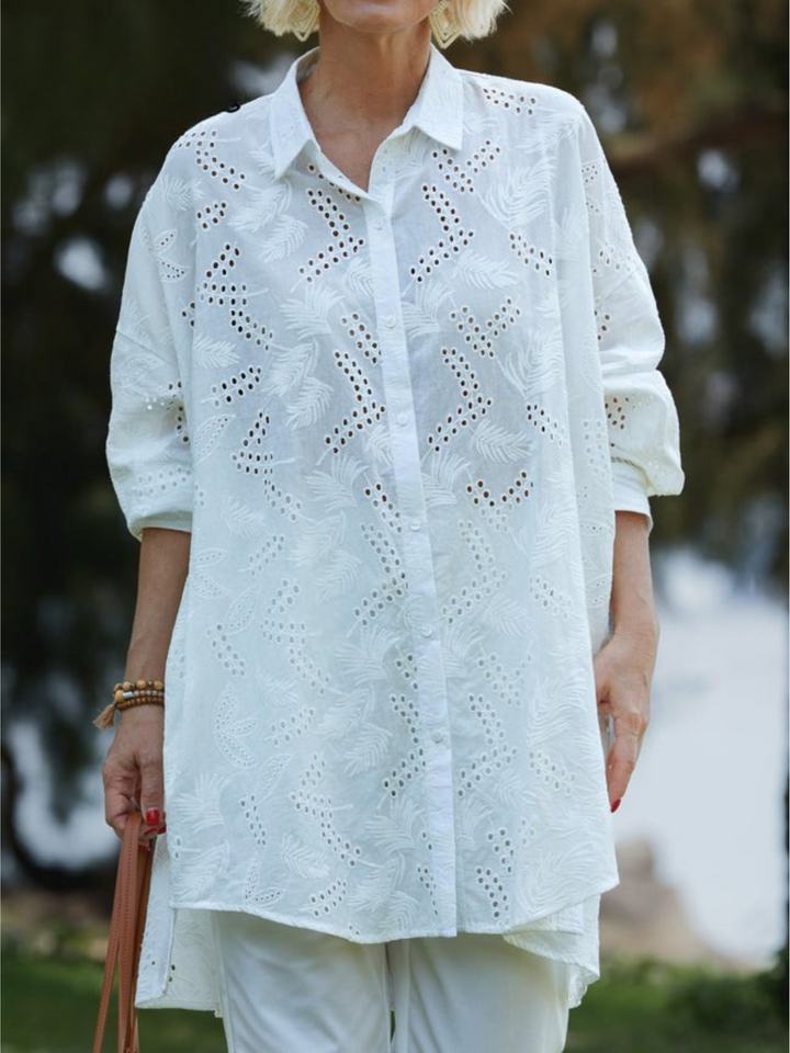 Front view of a model wearing a white cotton embroidery shirt with a natural leaf pattern