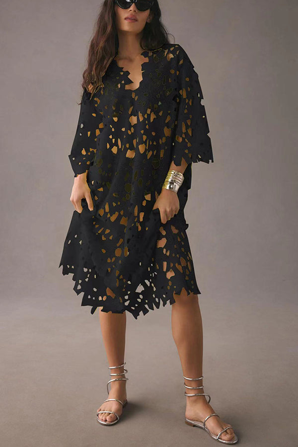 Front view of a model in a black floral eyelet lace midi beach cover up dress, silver sandals and sunglasses