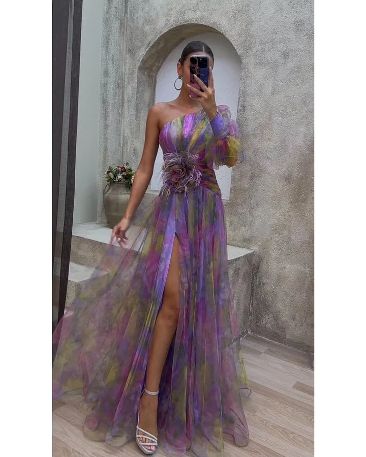 Front view, elegant floral dress worn by model, one shoulder with puffy sleeve and high leg split