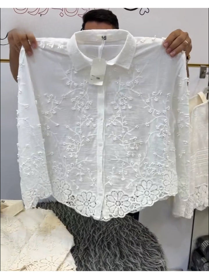 Back view of a white cotton casual shirt with 3D flower embroidery and a scalloped hem held up by hands