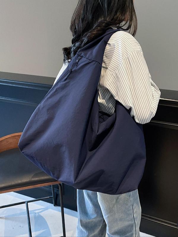 Side view, worn by model, of a navy Lush Everyday Tote Bag over a striped shirt and jeans