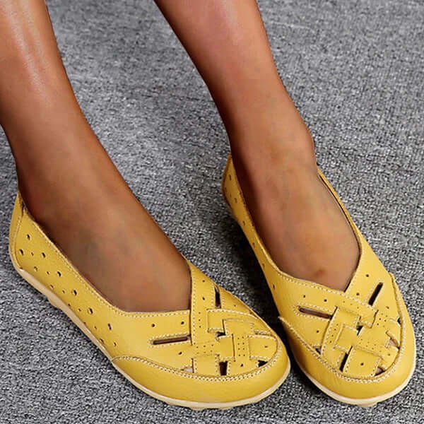 Worn by model, yellow breathable leather loafers with woven toe and perforated sides on a grey carpet
