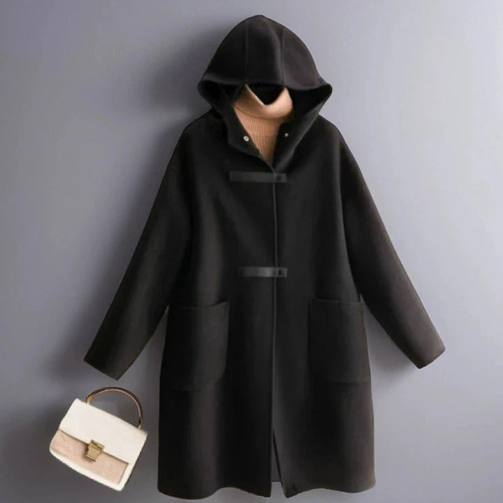 Front view of a black soft wool coat with a hood, toggle closures, and large front pockets, styled with a beige turtleneck