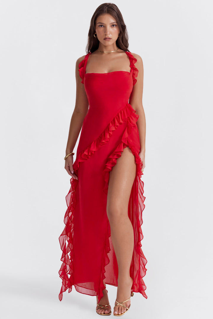 Full length front view of a model in a red georgette wedding guest dress with ruffled straps and a high split