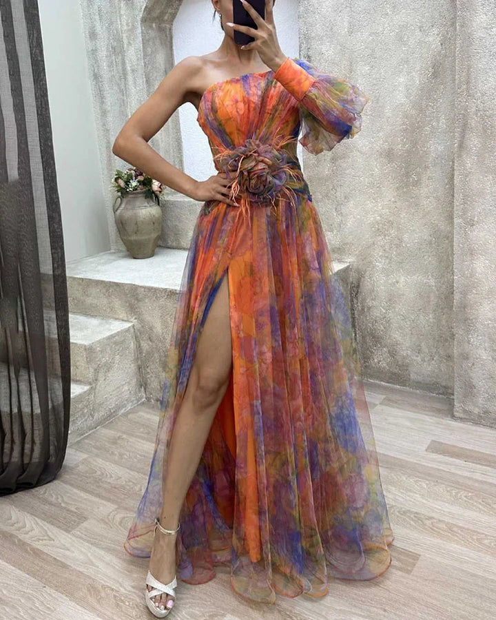 Front view, elegant floral dress with one puffy sleeve, high leg split, and feather waist detail, worn by model taking a
