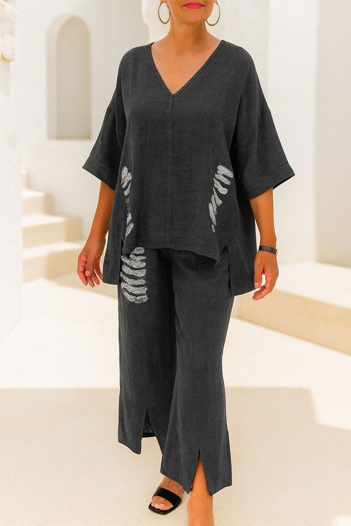 Front view of a model wearing a dark grey V neck half sleeve top and pants set with silver embroidery