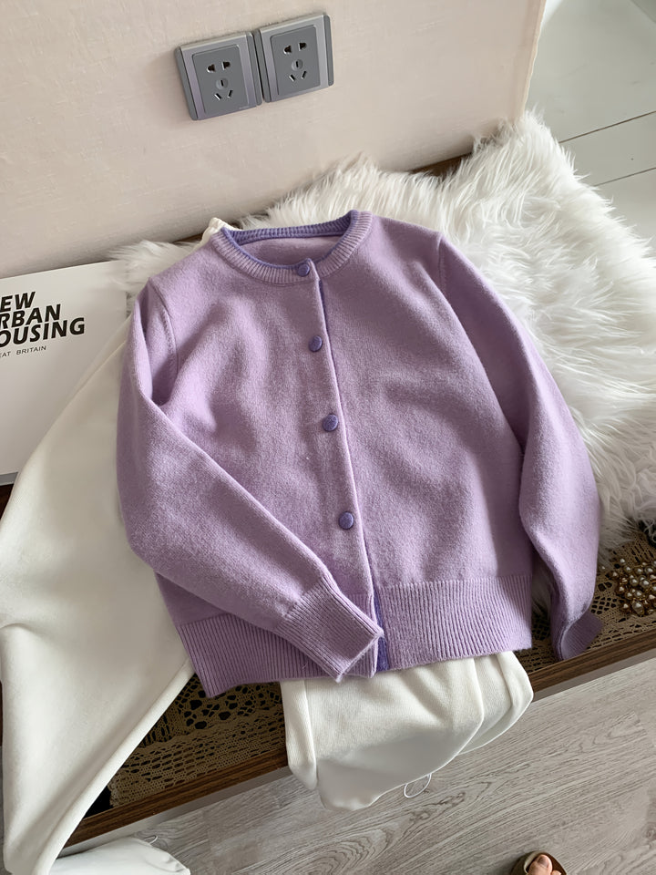 Flat lay of a purple knitted buttoned cardigan with light purple buttons and trim