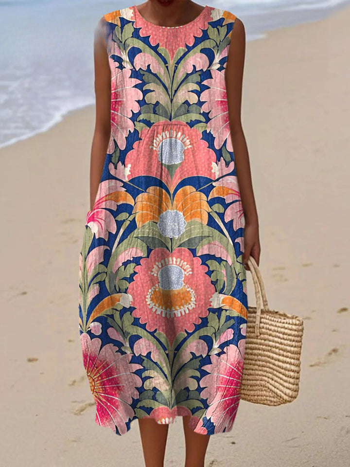 Front view of a model wearing a sleeveless vintage flower print cotton wrap dress on a beach