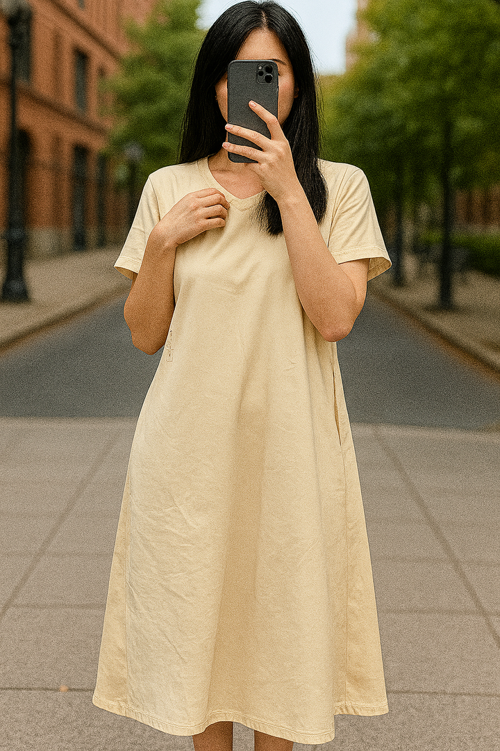 Front view, worn by model, of a flowing maxi dress in a light beige colour with short sleeves and pockets