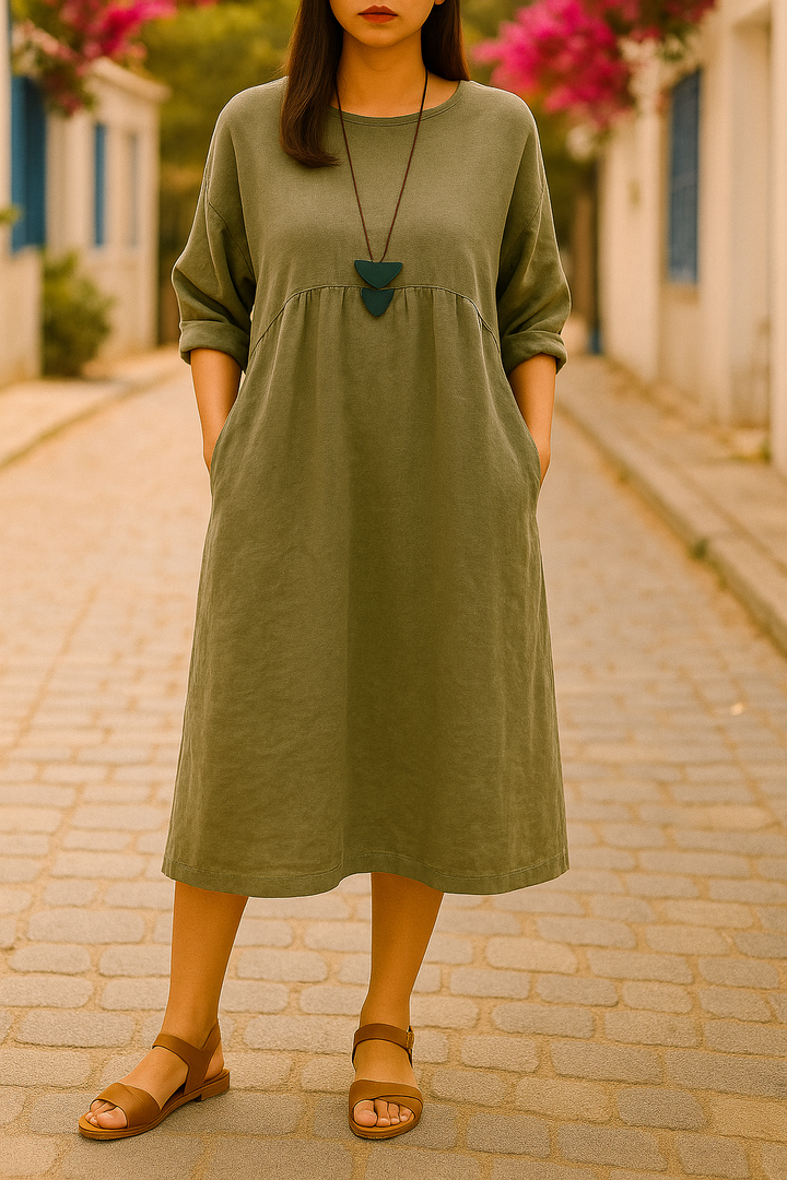Front view of a model wearing an olive green round neck 3/4 sleeve boho dress with pockets and sandals