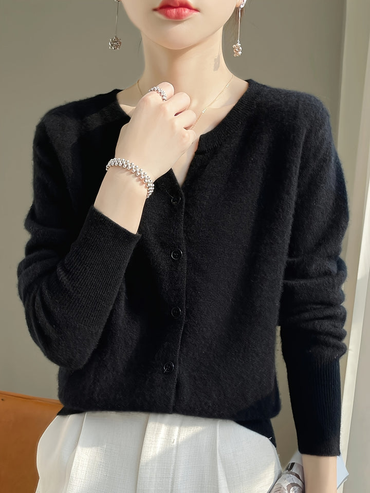 Close up of a model wearing the black buttoned knit cardigan with pearl drop earrings and a silver bracelet
