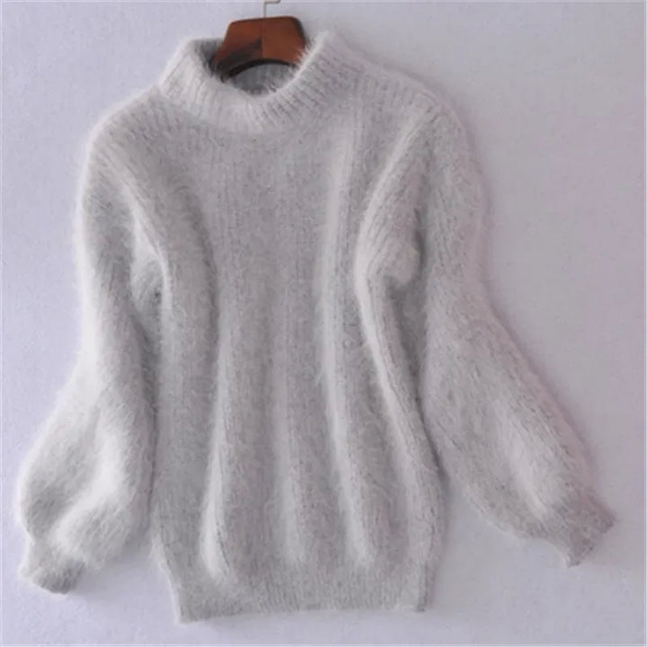 Back view of a white angora wool jumper with a ribbed high neck and voluminous sleeves on a hanger