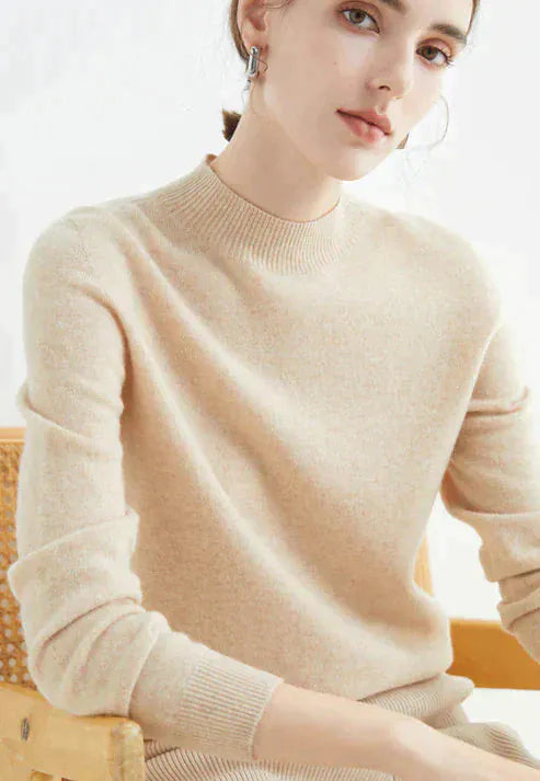 Close up, model wearing a beige cashmere mock-neck jumper with ribbed collar and cuffs