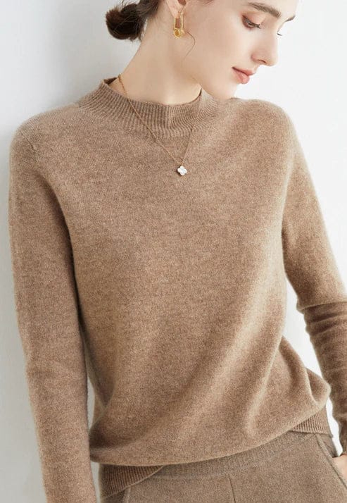 Close up, model wearing a beige cashmere mock-neck jumper with a gold necklace and earrings