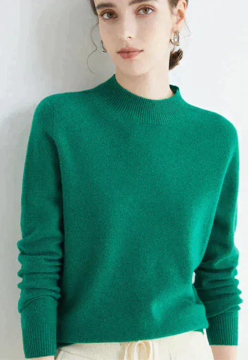 Close up, model wearing a bright green cashmere mock-neck jumper with ribbed collar and cuffs