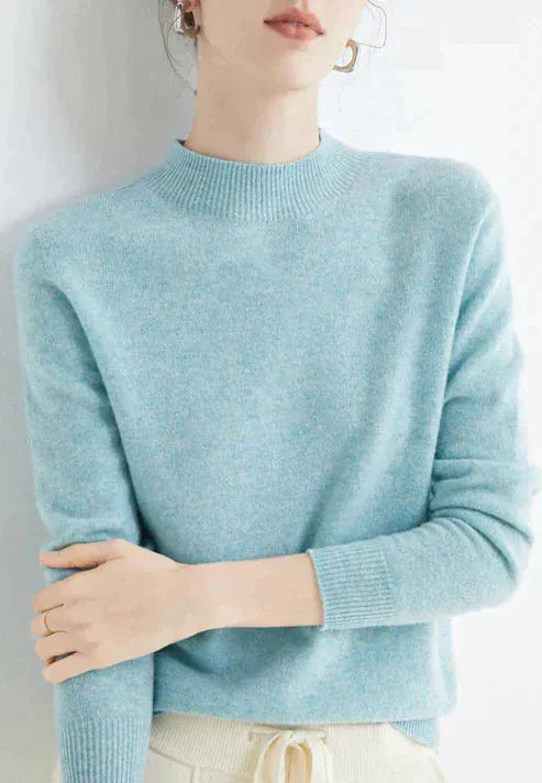 Front view, model wearing a light blue cashmere mock-neck jumper with ribbed collar and cuffs, light coloured pants