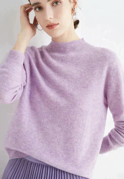 Front view, model wearing a lilac cashmere mock-neck jumper with ribbed collar and cuffs, matching pleated skirt