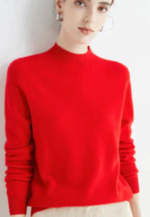 Front view, model wearing a red cashmere mock-neck jumper with ribbed collar and cuffs, light coloured pants