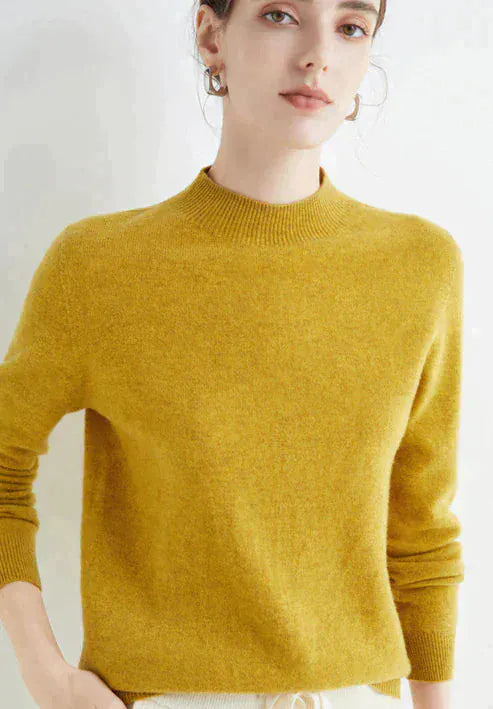 Close up, model wearing a mustard cashmere mock-neck jumper with ribbed collar and cuffs