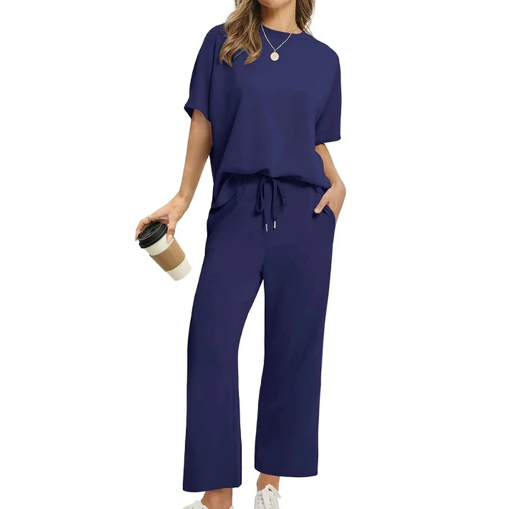Front view, model wearing a comfortable two-piece casual top and pants set in blue with a coffee cup, alternate angle