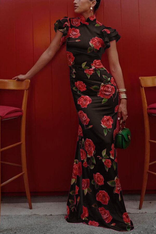 Side view, elegant rose floral print long dress with ruffled sleeves and turtleneck worn by model leaning on a chair
