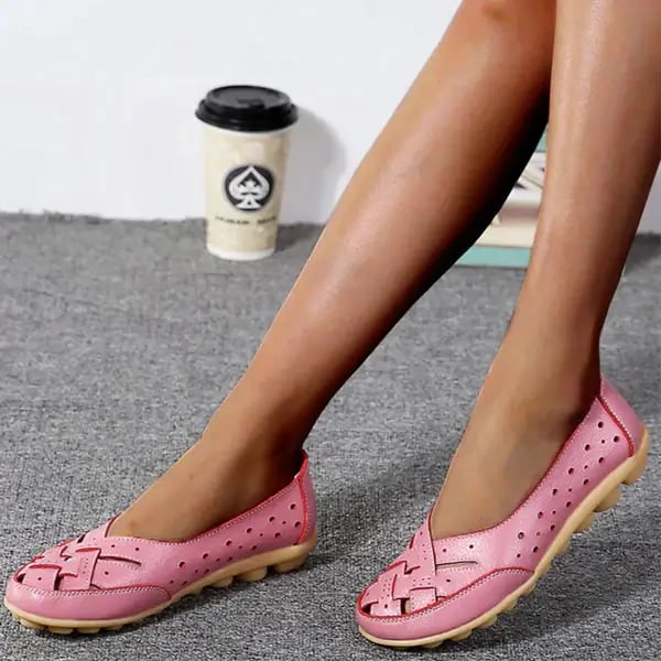 Worn by model, a pair of pink breathable leather loafers with woven toe and perforated sides