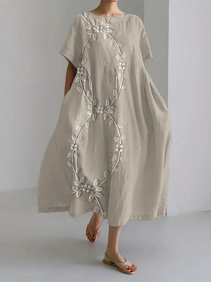 Elegant long dress, full length front view, with white vine embroidery design on light beige linen blend fabric