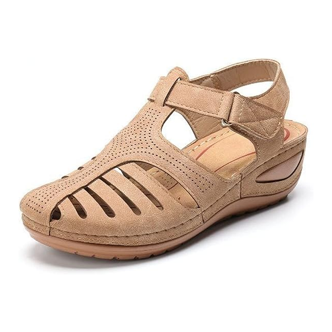 Front three quarter view of a single tan orthopedic summer sandal with cutouts, perforated detail, and a velcro strap