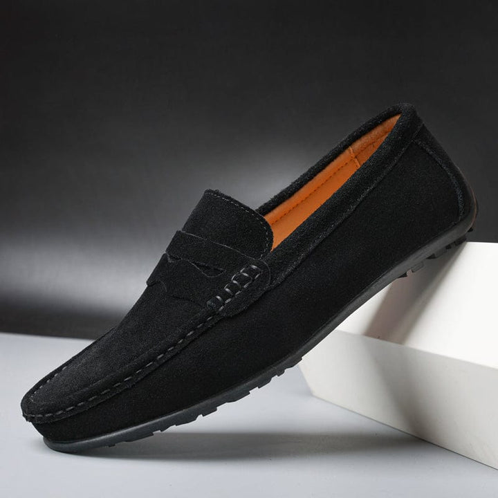 Black suede loafer, three quarter view, with a black sole and tan interior