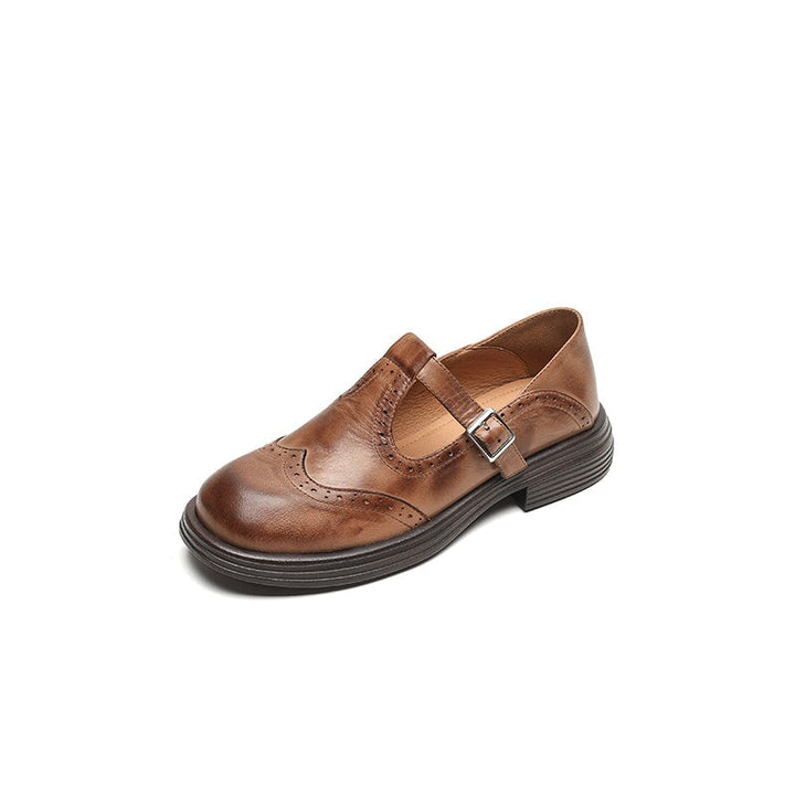 Side view of an elegant brown Mary Jane leather shoe with brogue detailing and a silver buckle on a white background