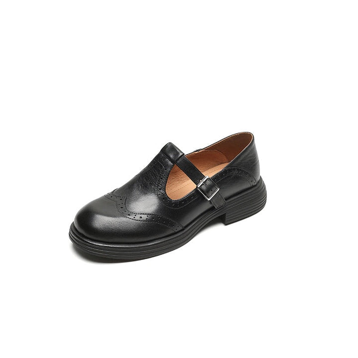 Three quarter view of a single black elegant Mary Jane leather shoe with brogue detailing and a silver buckle