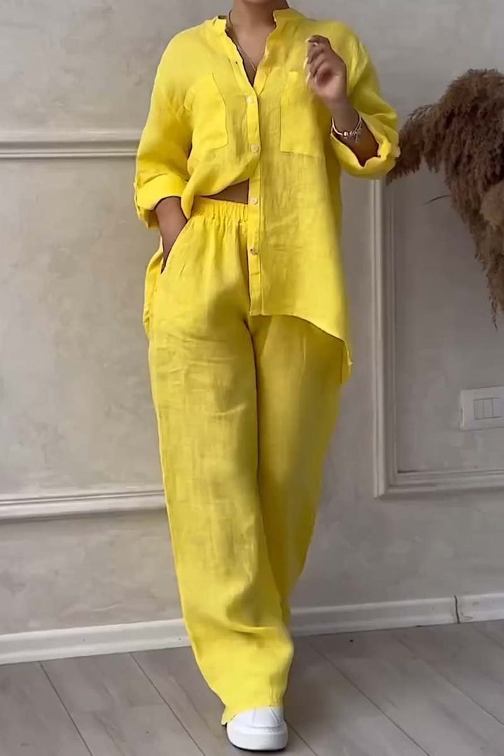 Front view of a model in a bright yellow long sleeve blouse and wide leg pants set