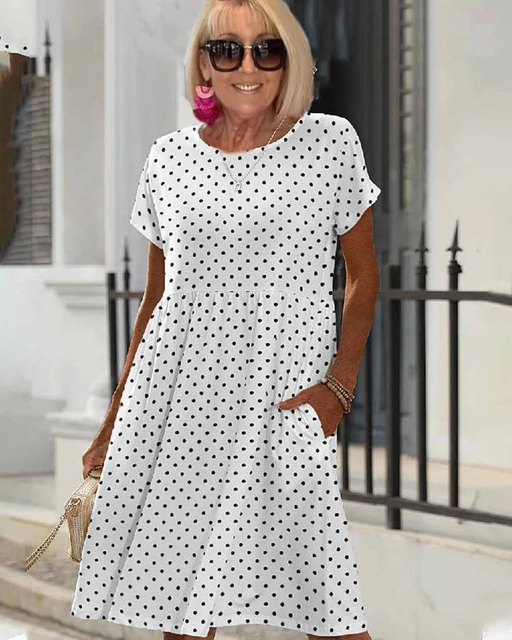 Casual Summer Dress, polka dot print, worn by model, with hand in pocket and pink tassel earrings