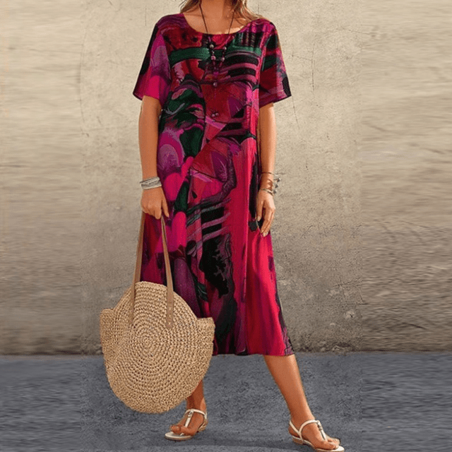 Front view of the floral midi dress with a pink, black and green abstract print worn by a model