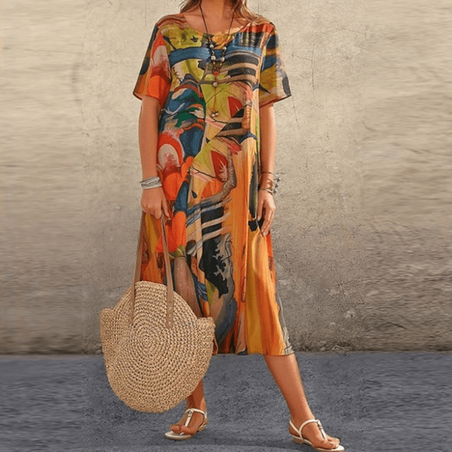 Front view of the floral midi dress with an orange, blue and black abstract print worn by a model