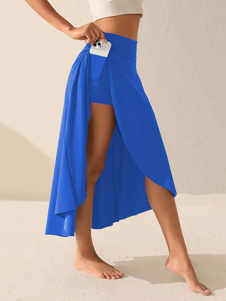 Side view, model wearing a plus-size asymmetric sports skirt with phone in pocket and bare feet
