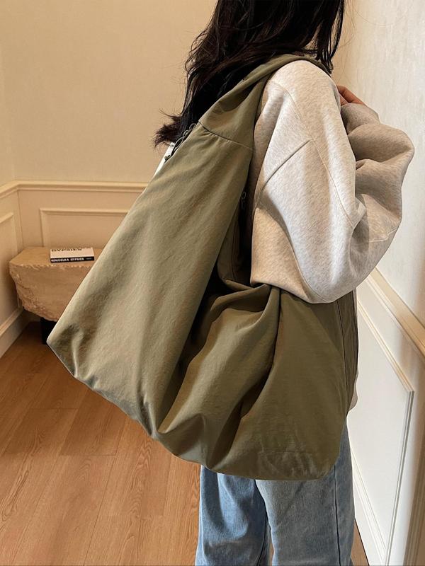 Side view, worn by model, of a green Lush Everyday Tote Bag over a grey hoodie and blue jeans