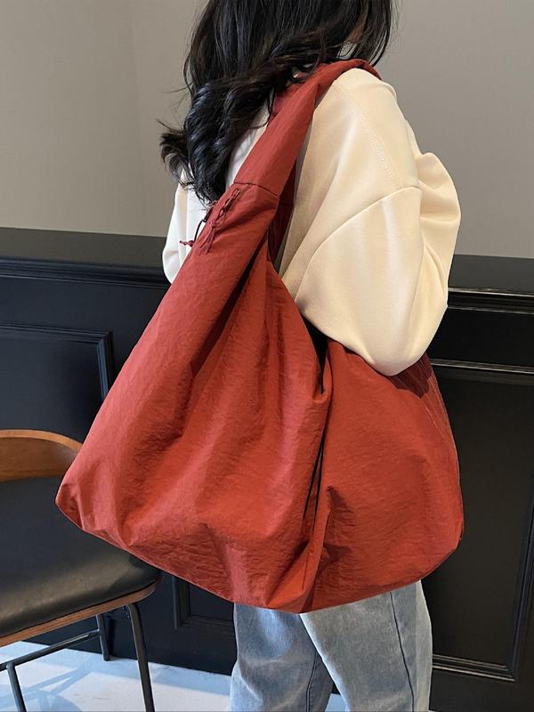 Back view, worn by model, of a rust Lush Everyday Tote Bag over a cream jumper and light blue jeans