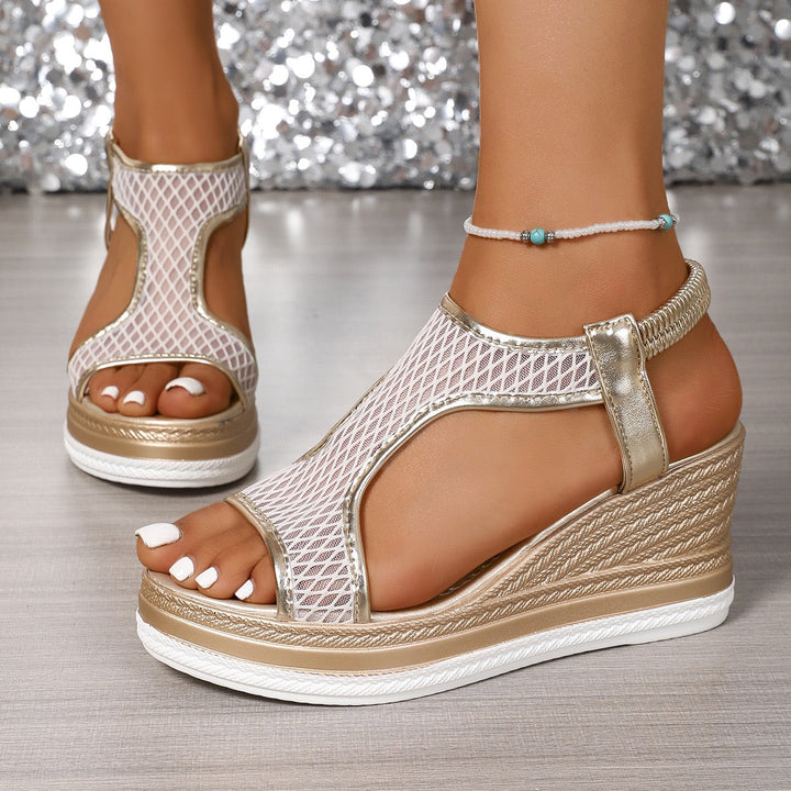 Side view of a model wearing elegant gold and white arch-support wedge sandals with mesh detail and ankle strap