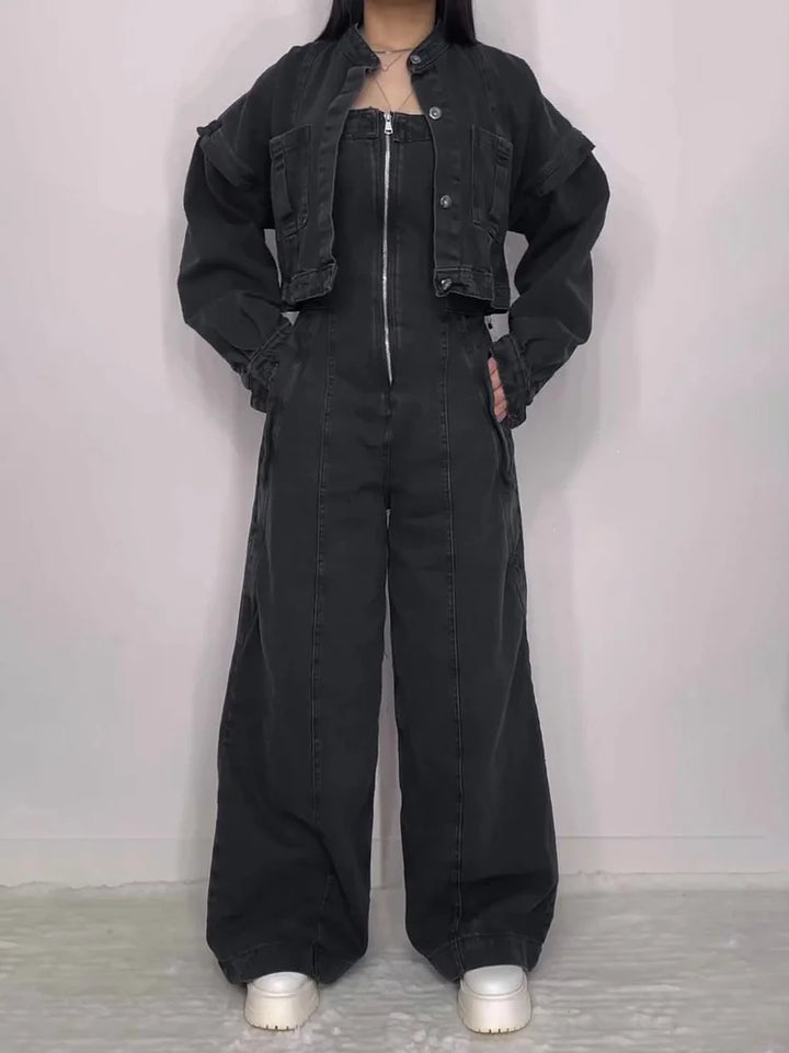 Front view of a model in a chic denim zipper jumpsuit and matching jacket with hands in pockets