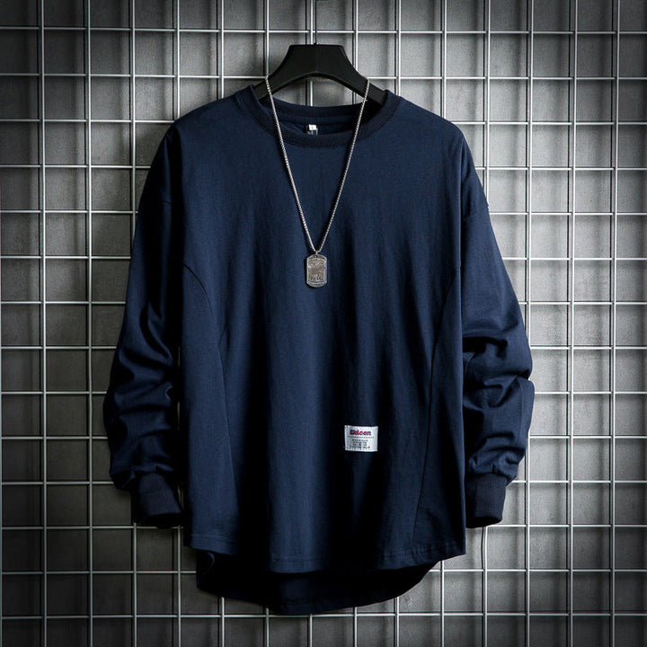 Front view of a navy blue oversized cotton hooded sweater with a rounded hem and a dog tag necklace