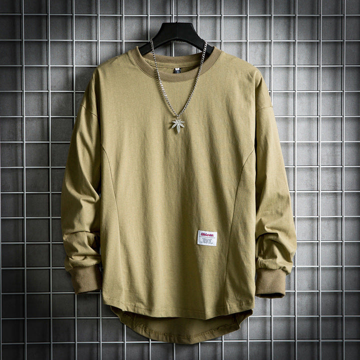 Front view of a khaki oversized cotton hooded sweater with a rounded hem and a leaf pendant necklace and white label