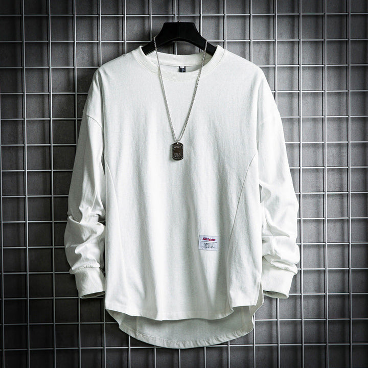 Front view of a white oversized cotton hooded sweater with a rounded hem and a dog tag necklace