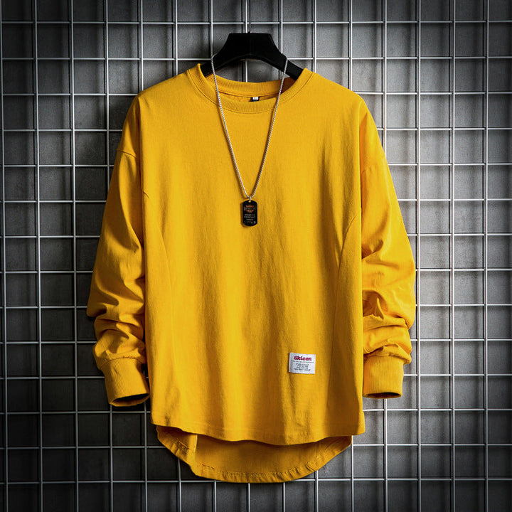 Front view of a yellow oversized cotton hooded sweater with a rounded hem and a dog tag necklace and white label