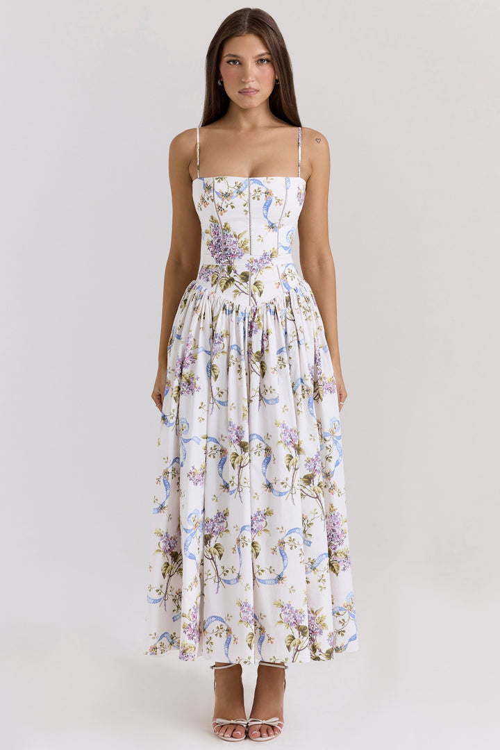 Front view, model wearing a white cotton maxi sundress with a shirred bodice and lilac floral print