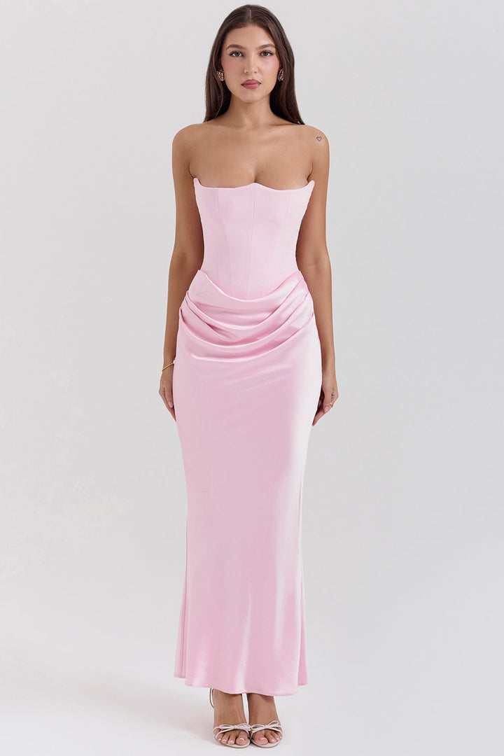 Front view of a model wearing a pink strapless corset dress with a ruched waist and long flowing skirt