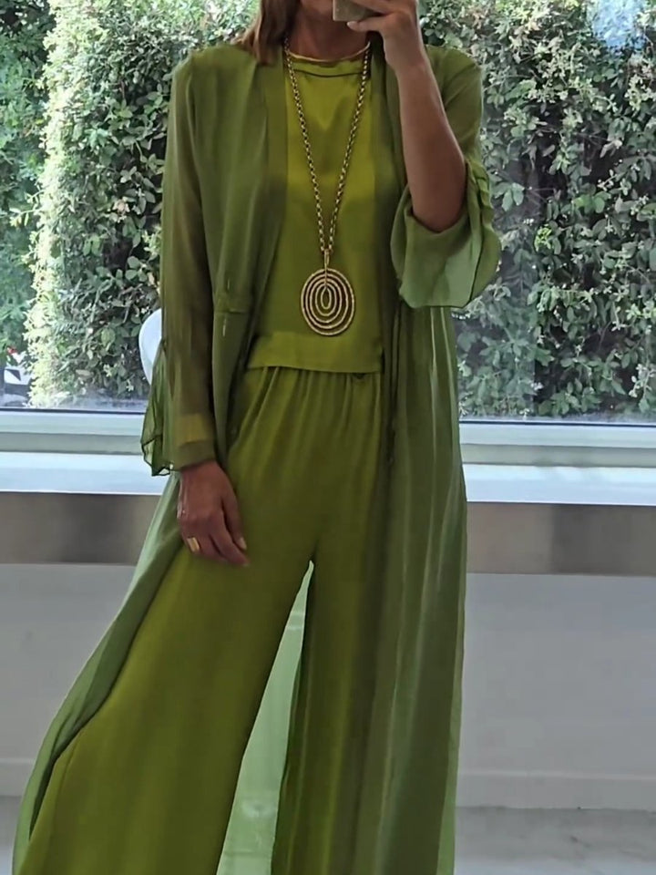 Close up of model wearing an elegant 3-piece polyester set in lime green with a long gold necklace